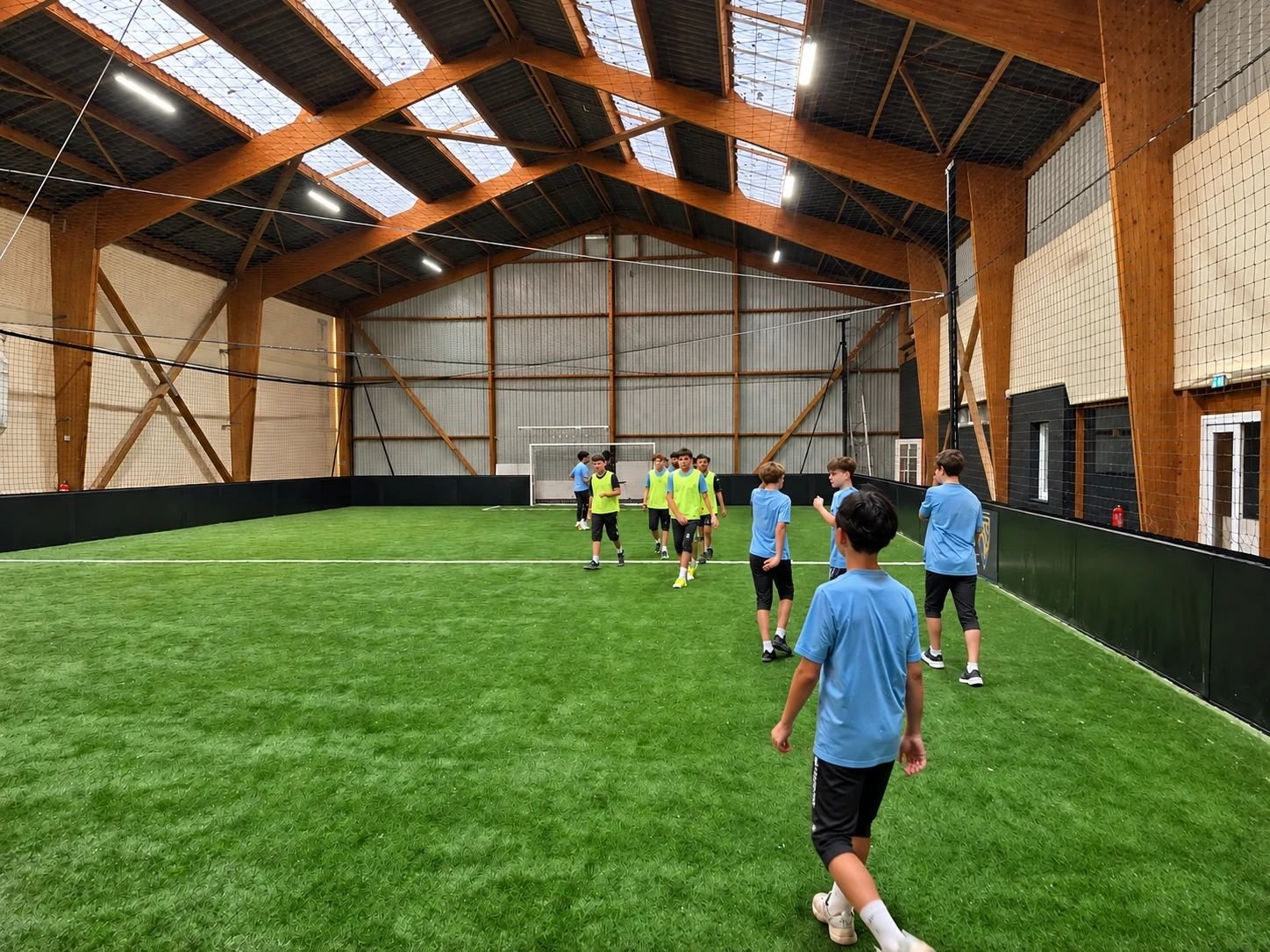 Groupe de jeunes joueurs à l’entraînement sur le terrain de foot à 5 indoor